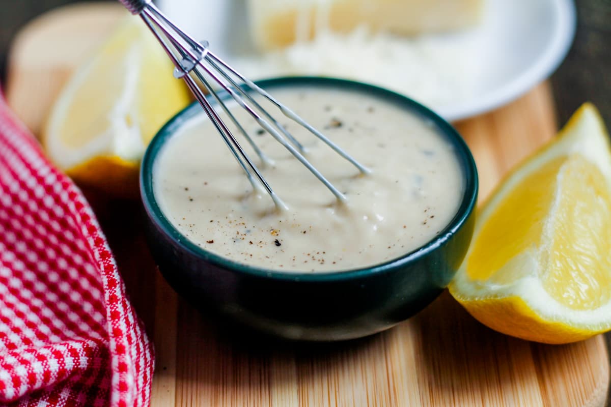 Caesar dressing with no egg being stirred with a whisk.