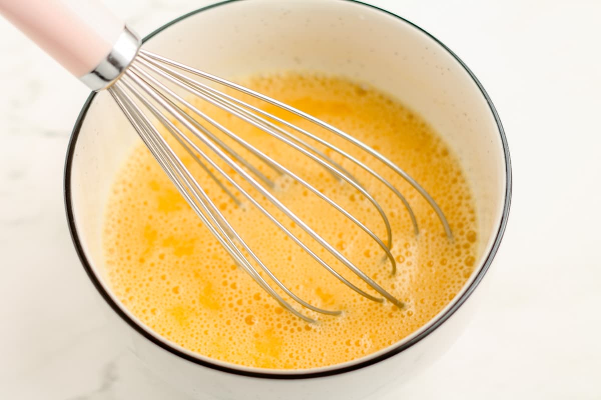 Wet ingredients being whisked in a bowl.