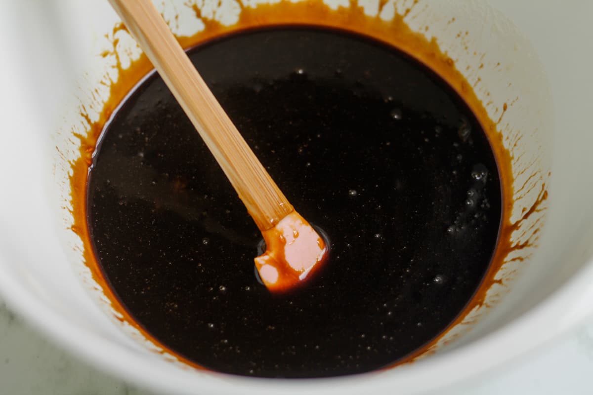 Molasses being stirred into the bowl of wet ingredients.