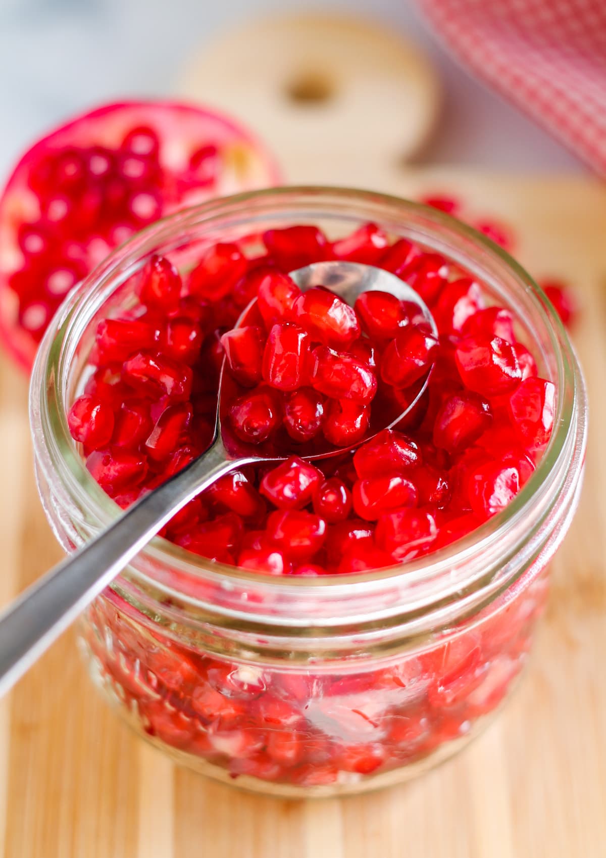A spoon of pomegranate seeds.