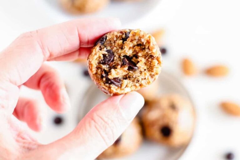 A hand holding an almond butter ball.