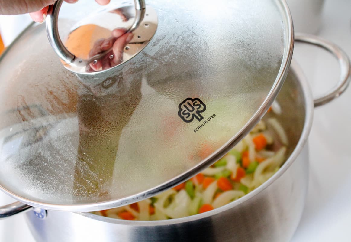 Ingredients being stirred in a soup pot.