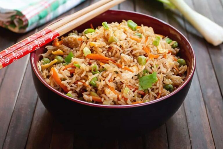 A bowl of fried rice with chopsticks.