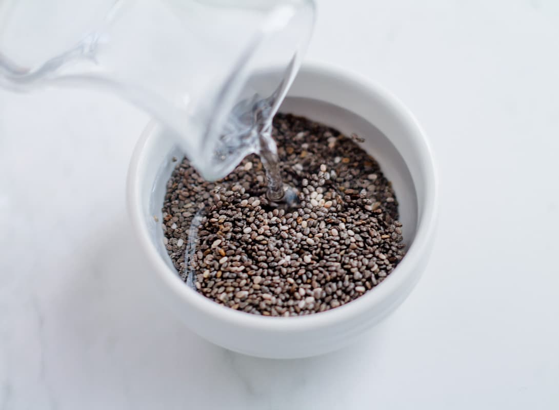 Water being poured onto dish of chia seeds.