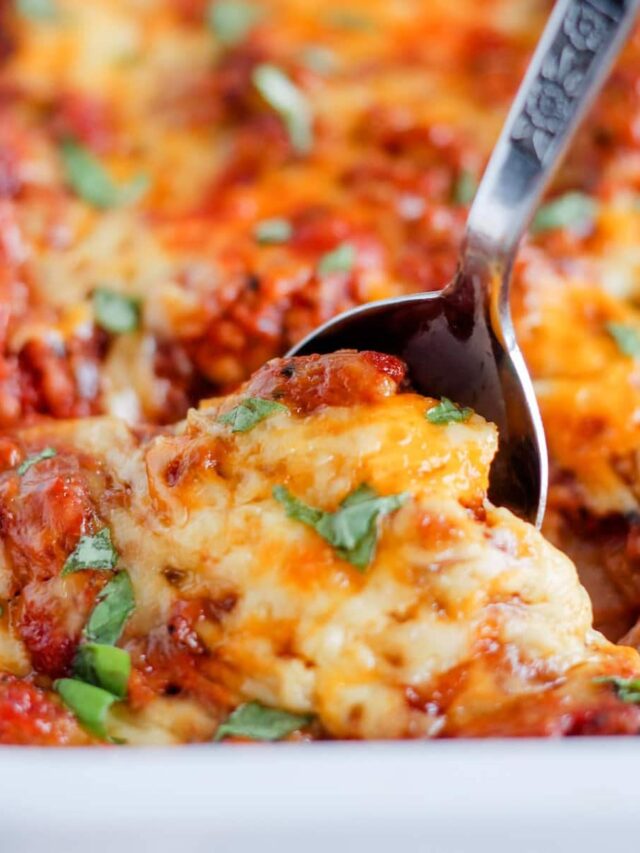 A spoon scooping ground beef casserole from a dish.