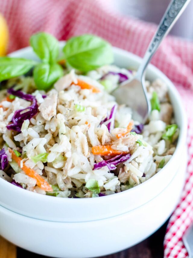 A bowl of rice salad with tuna with a fork in it.