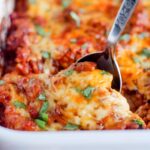 A spoon scooping ground beef casserole from a dish.