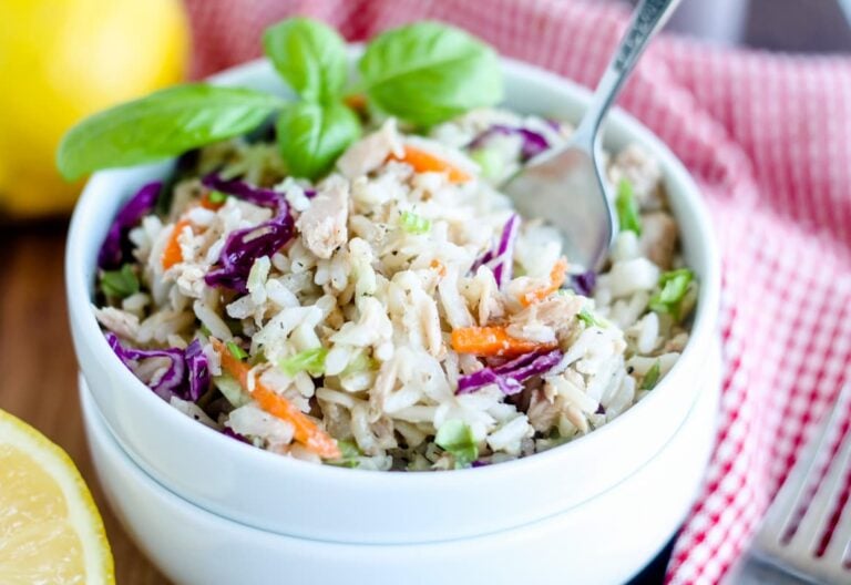 A bowl of rice salad with tuna with a fork in it.