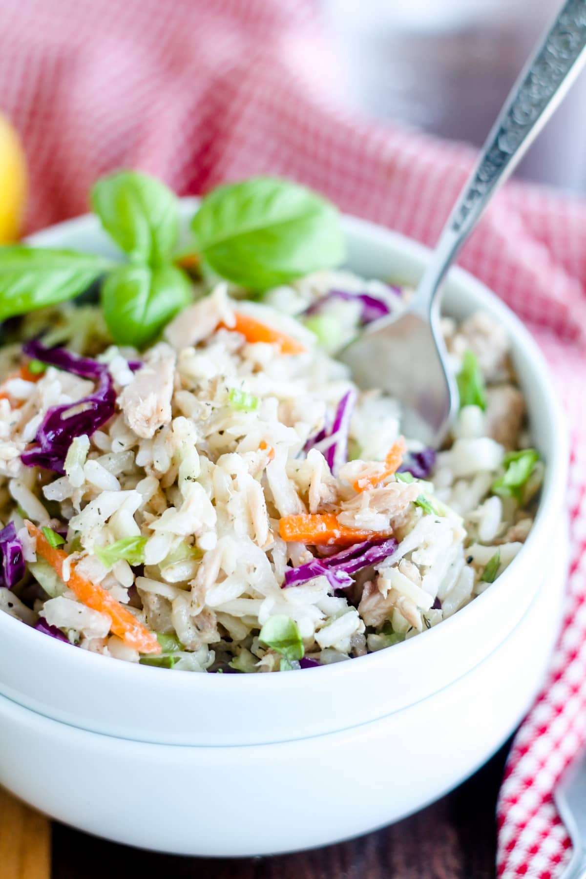 A bowl of rice salad with tuna with a fork in it.