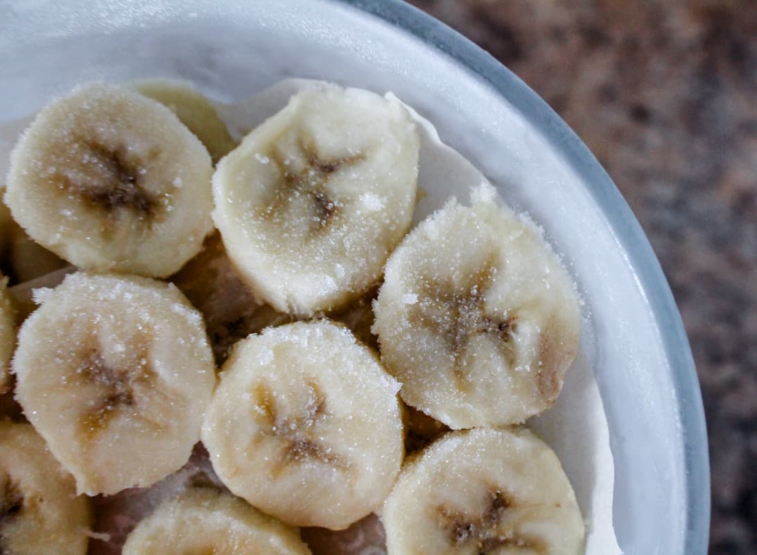 Frozen banana slices in a container.