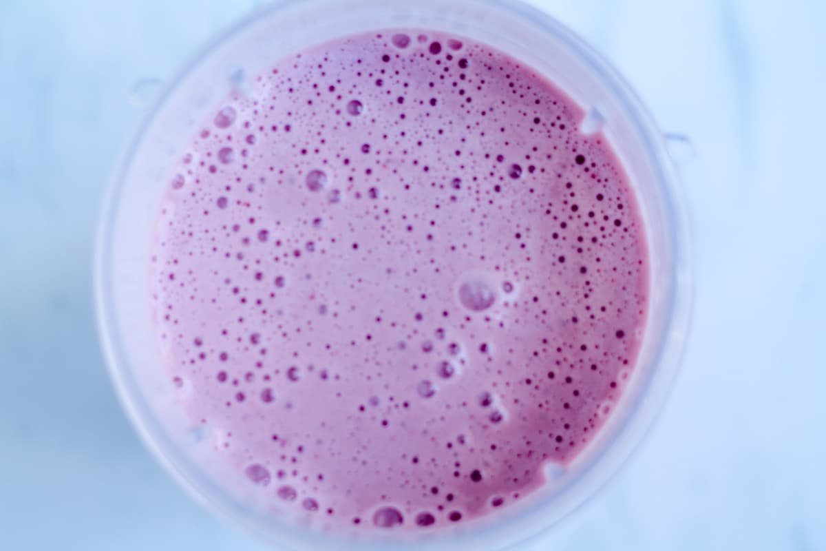 Overhead image of a blender with pink liquid inside.