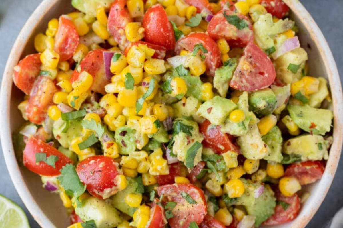 A bowl of corn tomato avocado salad.