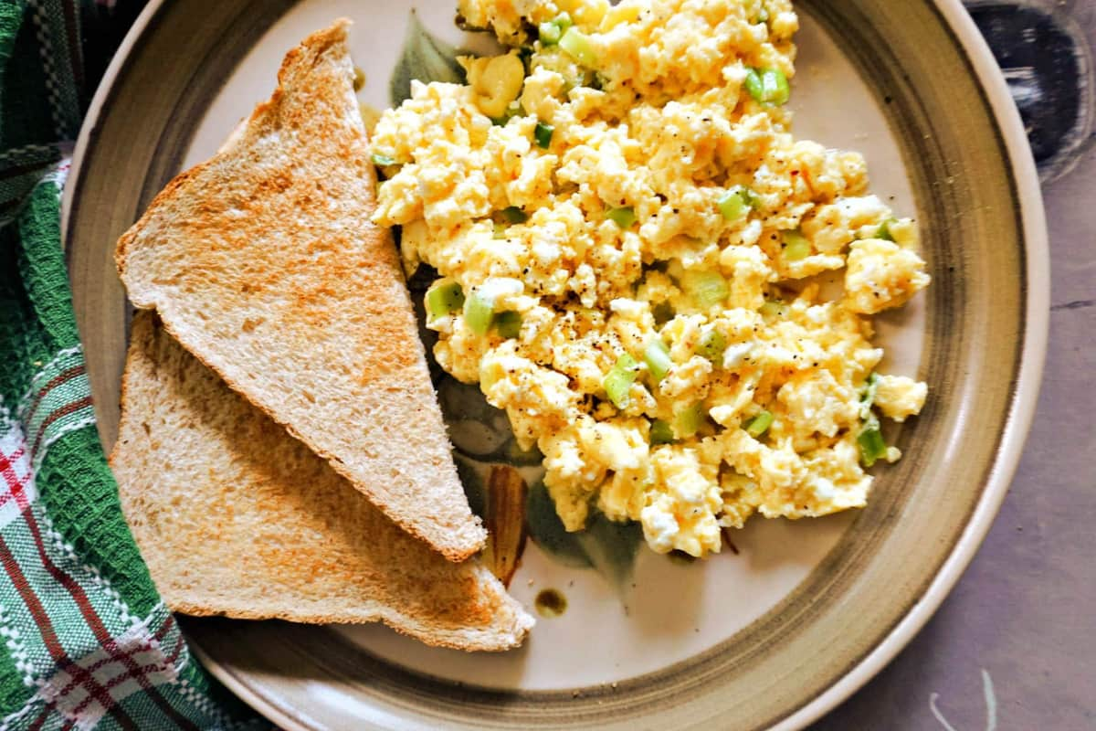 A plate of scrambled eggs with cottage cheese.