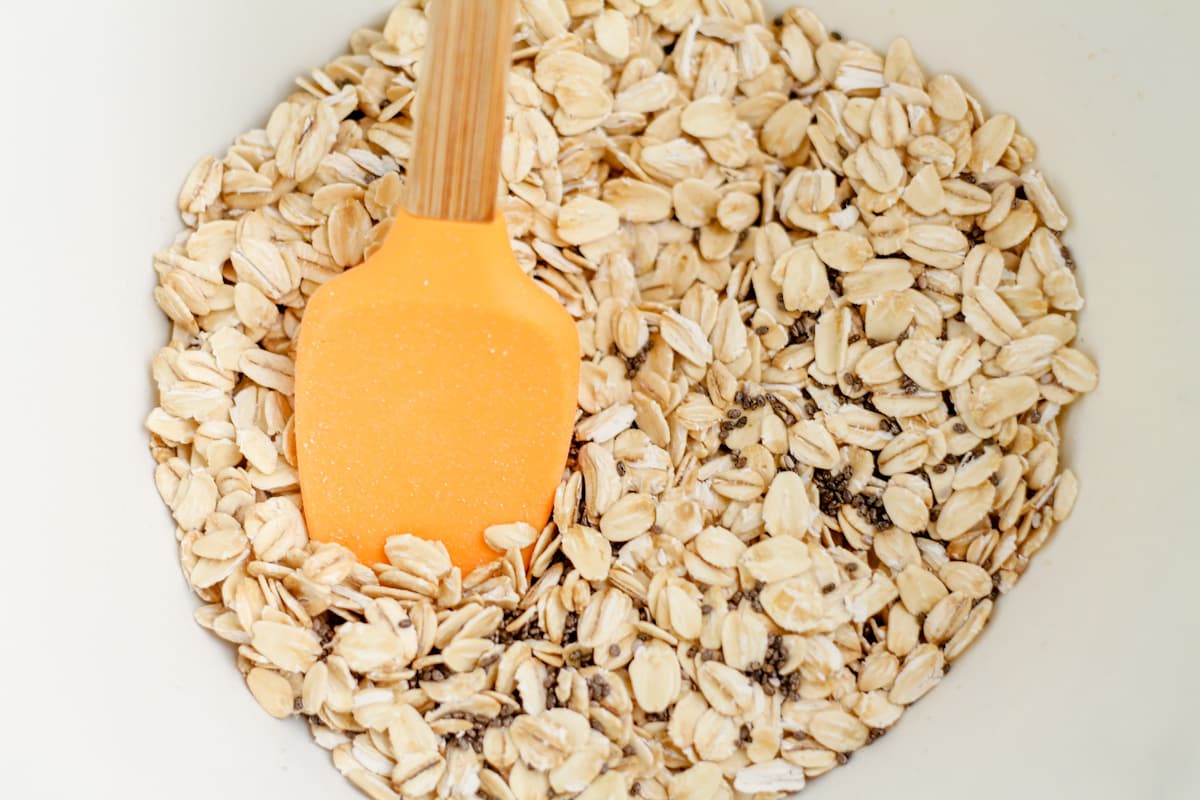 Oats and chia seeds being mixed in a bowl.