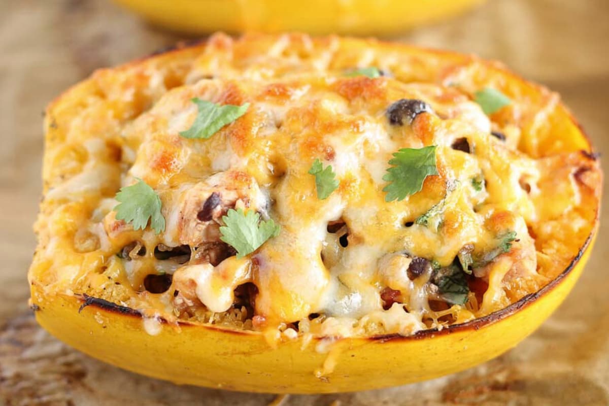 A stuffed spaghetti squash on a baking sheet.