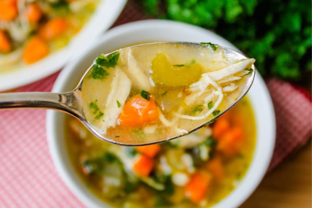 A bowl of chicken quinoa vegetable soup.