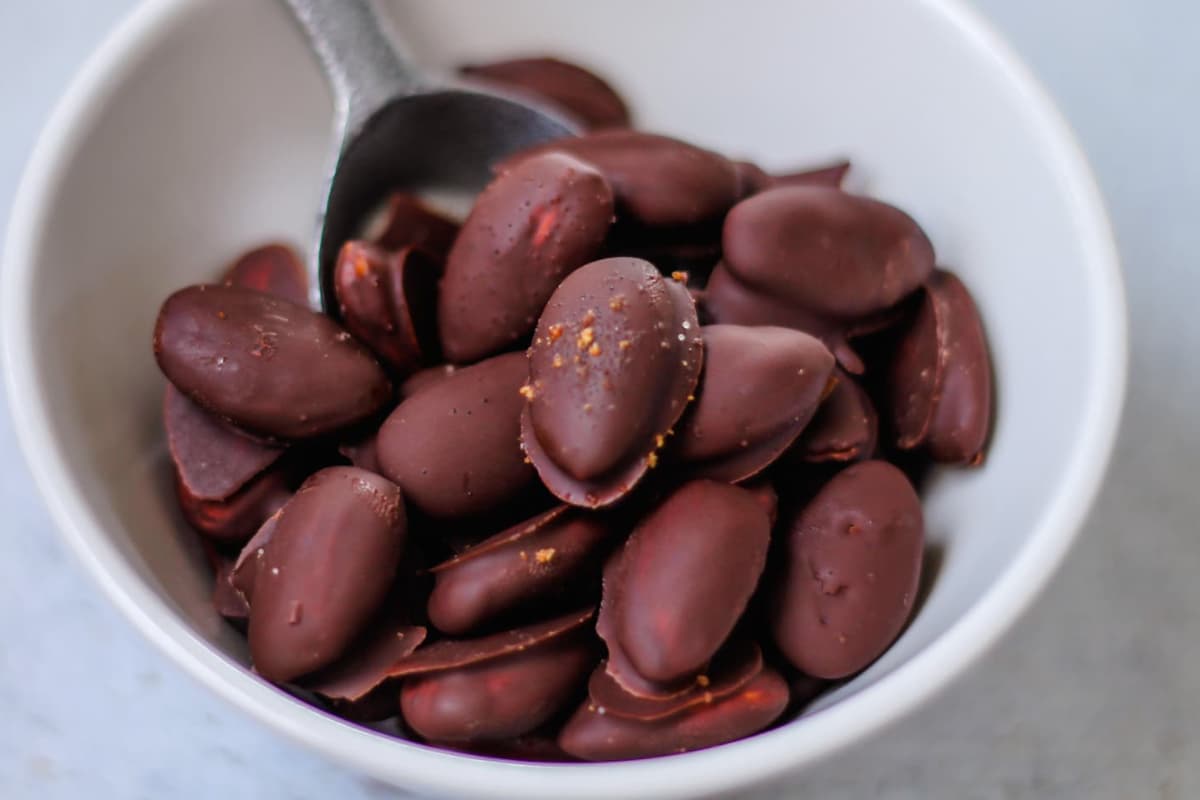 A bowl of chocolate covered almonds.