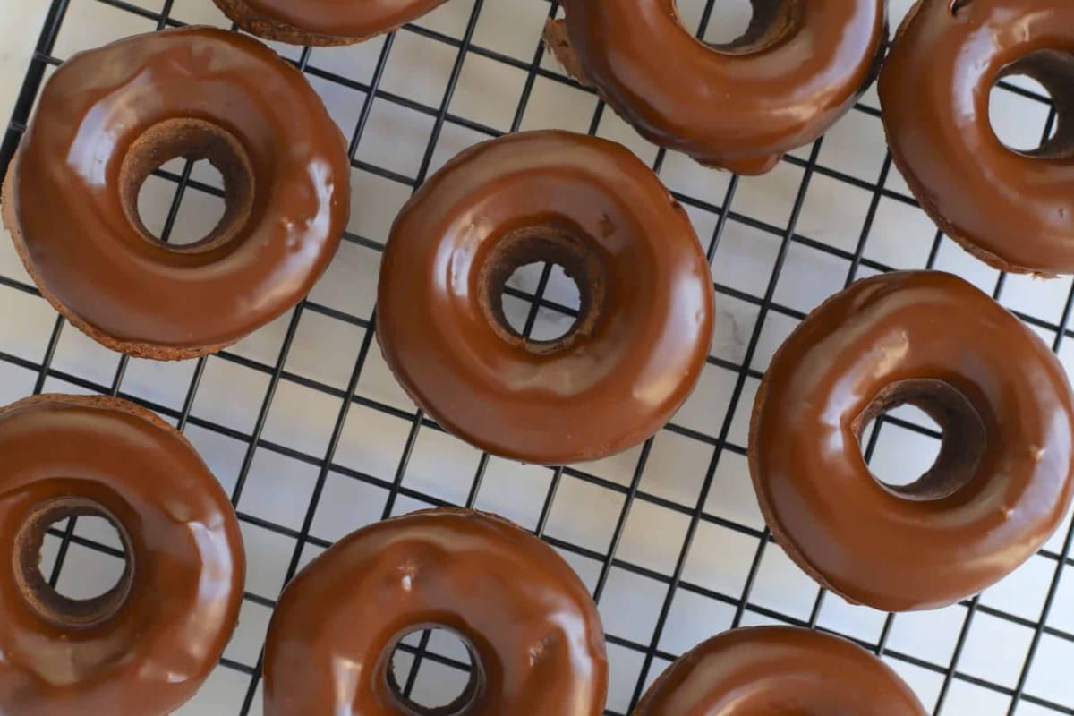 Sugar free chocolate donuts on a wire rack.