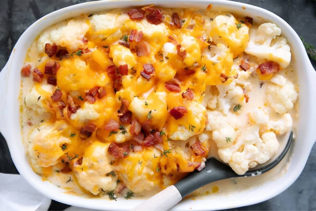 A dish of cheesy cauliflower with bacon.