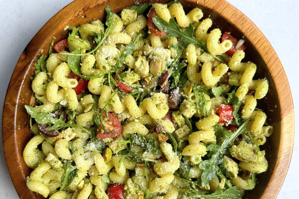 A bowl of chicken pesto pasta salad.