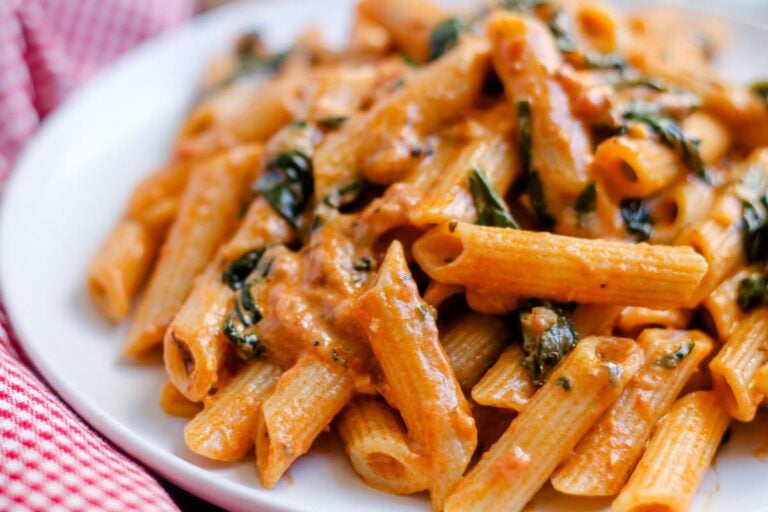 A plate of creamy tomato spinach pasta.