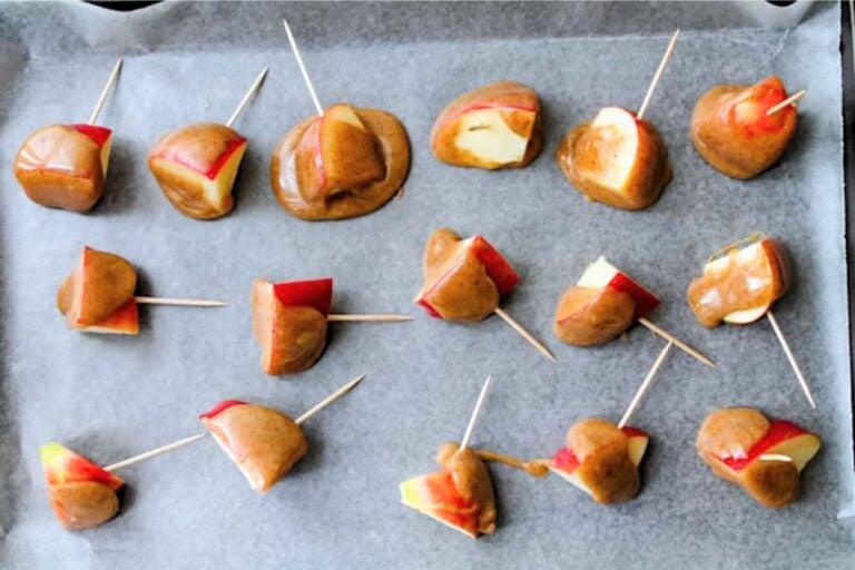 A tray of healthy caramel apples apples.