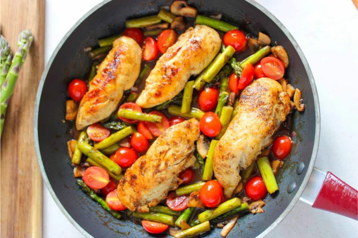 A pan of chicken and asparagus.