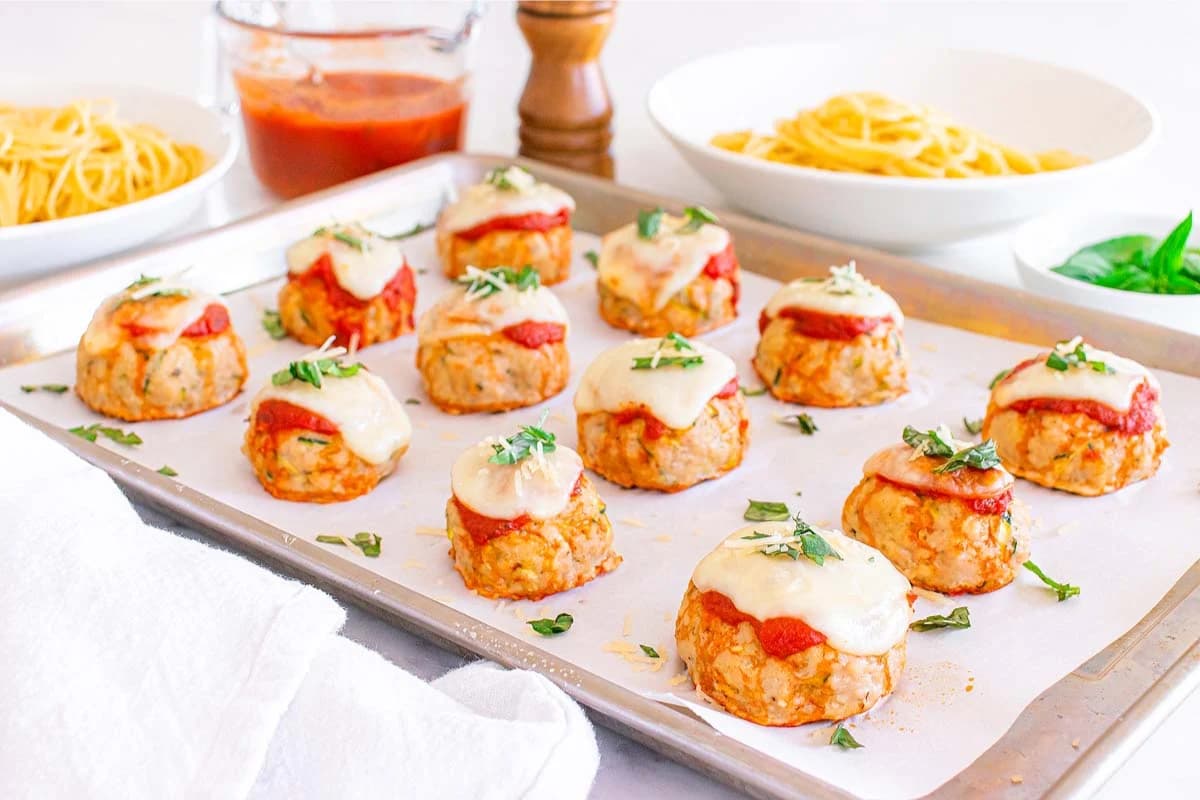 A sheet pan of chicken parmesan meatballs.