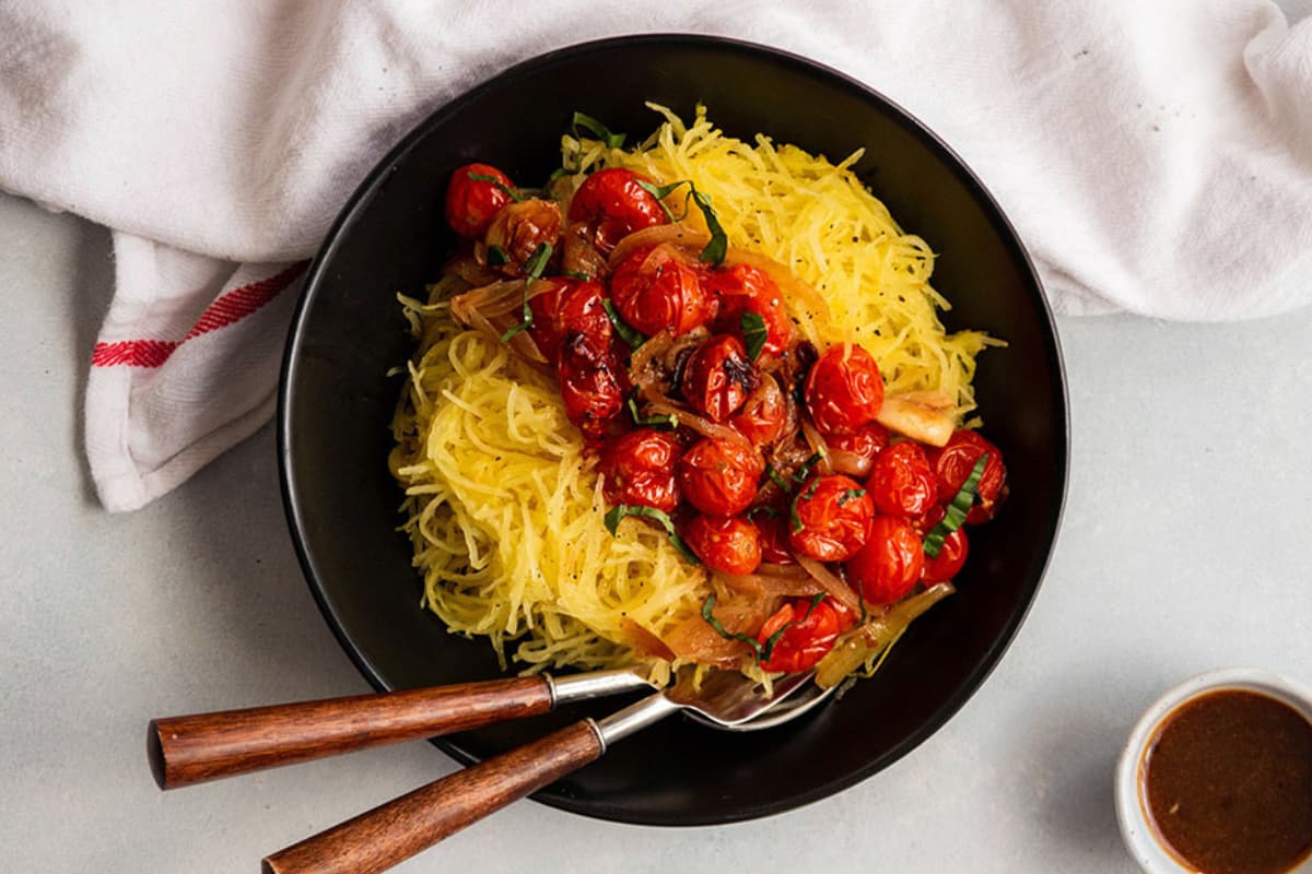 A bowl of spaghetti squash with roasted tomatoes.