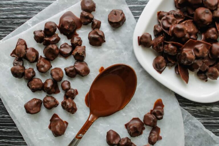 A plate of chocolate covered blueberries.