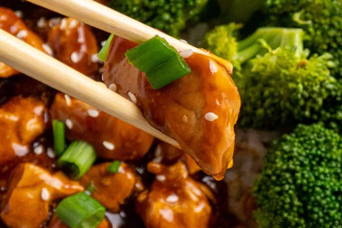 A chop stick holding teriyaki chicken.