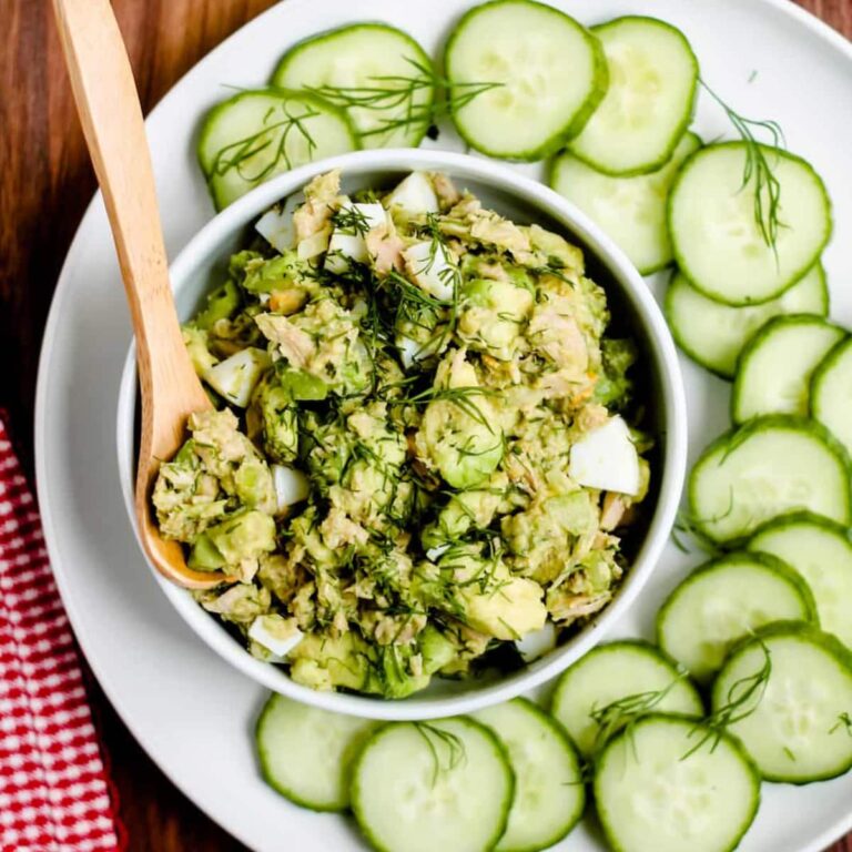 A spoon scooping out tuna and egg salad.