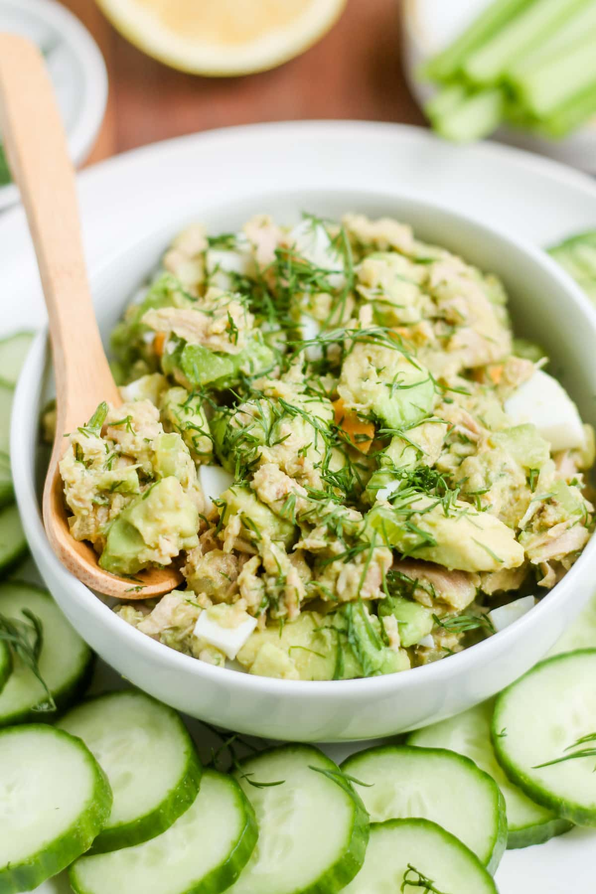 A spoon scooping out tuna and egg salad.