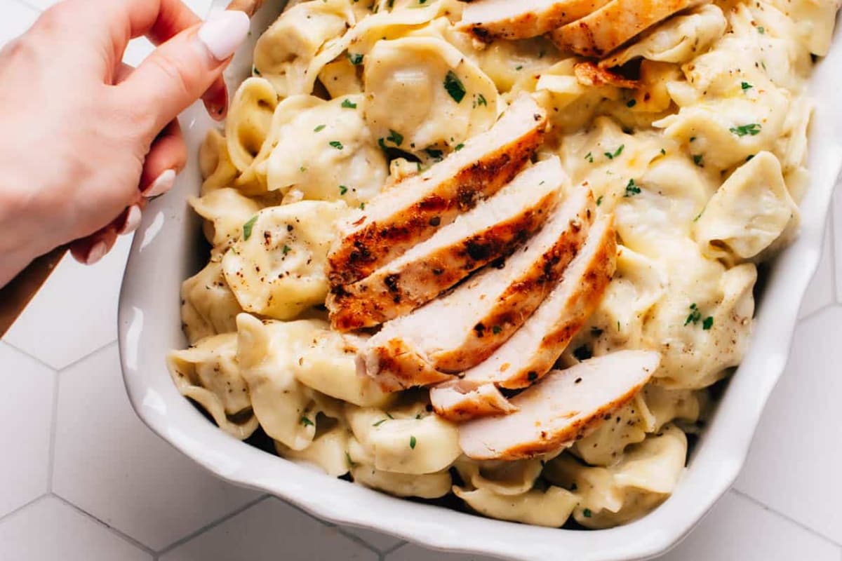 A casserole dish of asiago chicken tortelloni pasta.