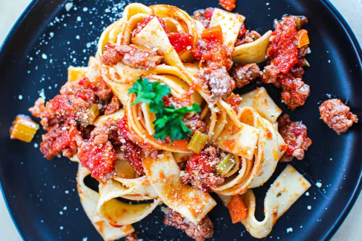 A plate of chicken bolognese pasta.