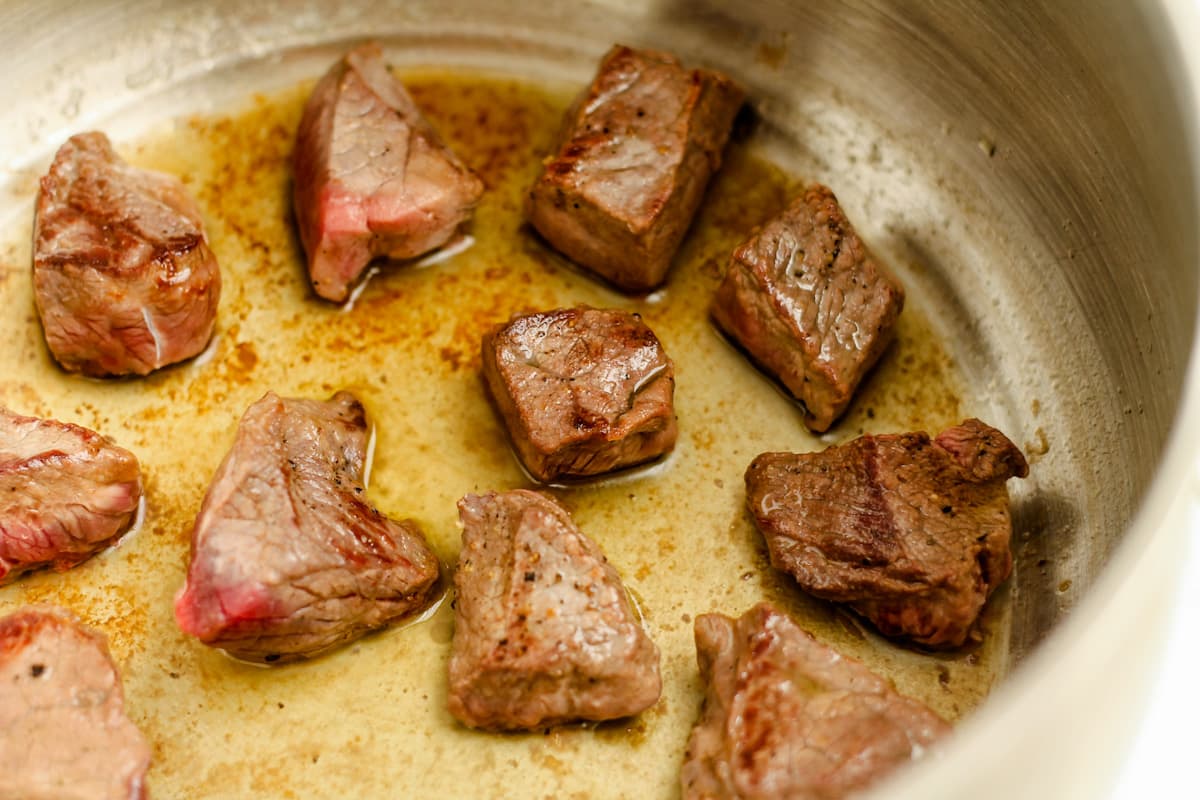 Cubes of meat browning in  pot.