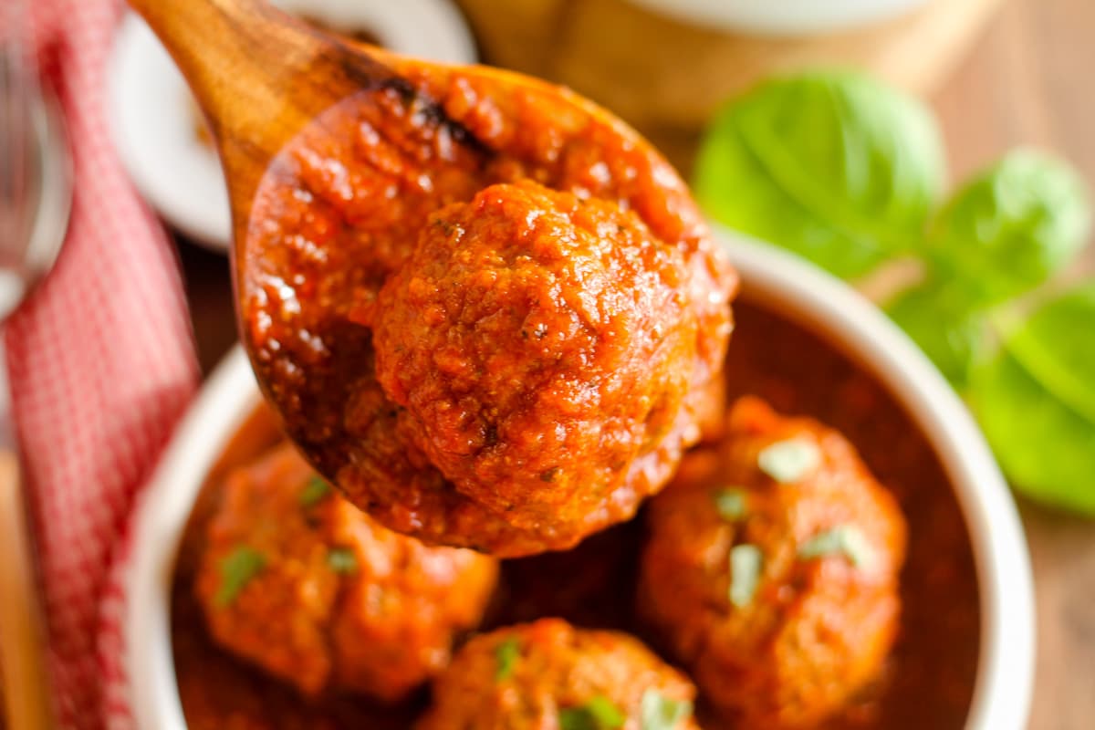 A spoon of meatballs and sauce.