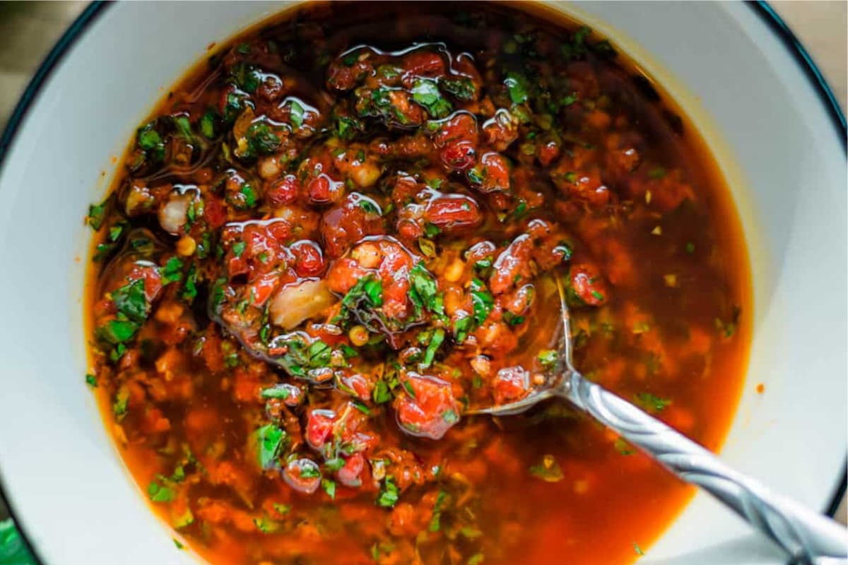 A bowl of red chimichurri sauce.