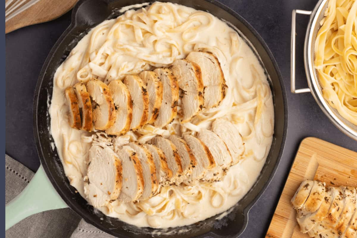 A skillet of chicken alfredo pasta.