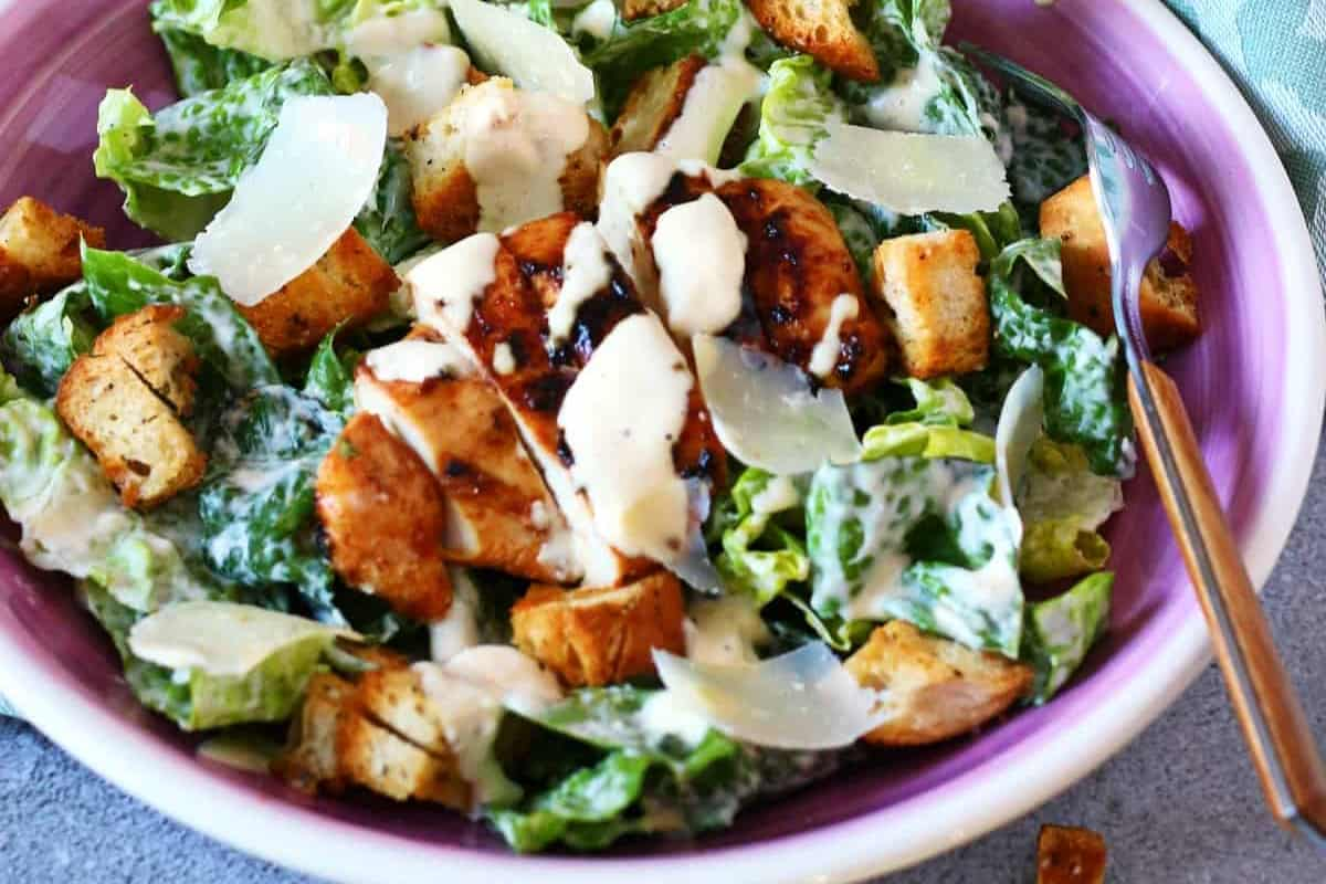 A bowl of chicken caesar salad.