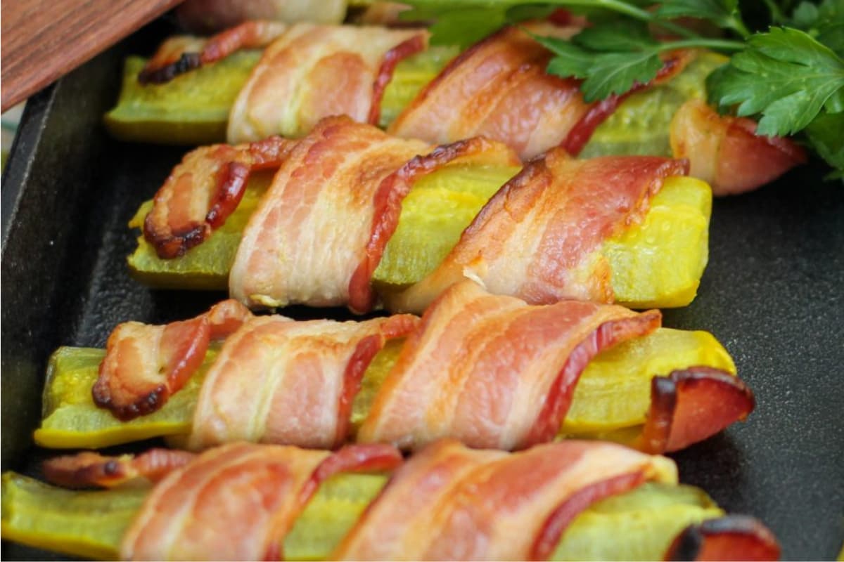 A plate of low carb bacon wrapped pickles.