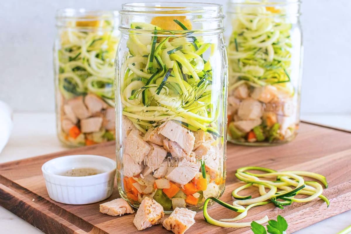 Mason jar chicken noodle soup on a counter.