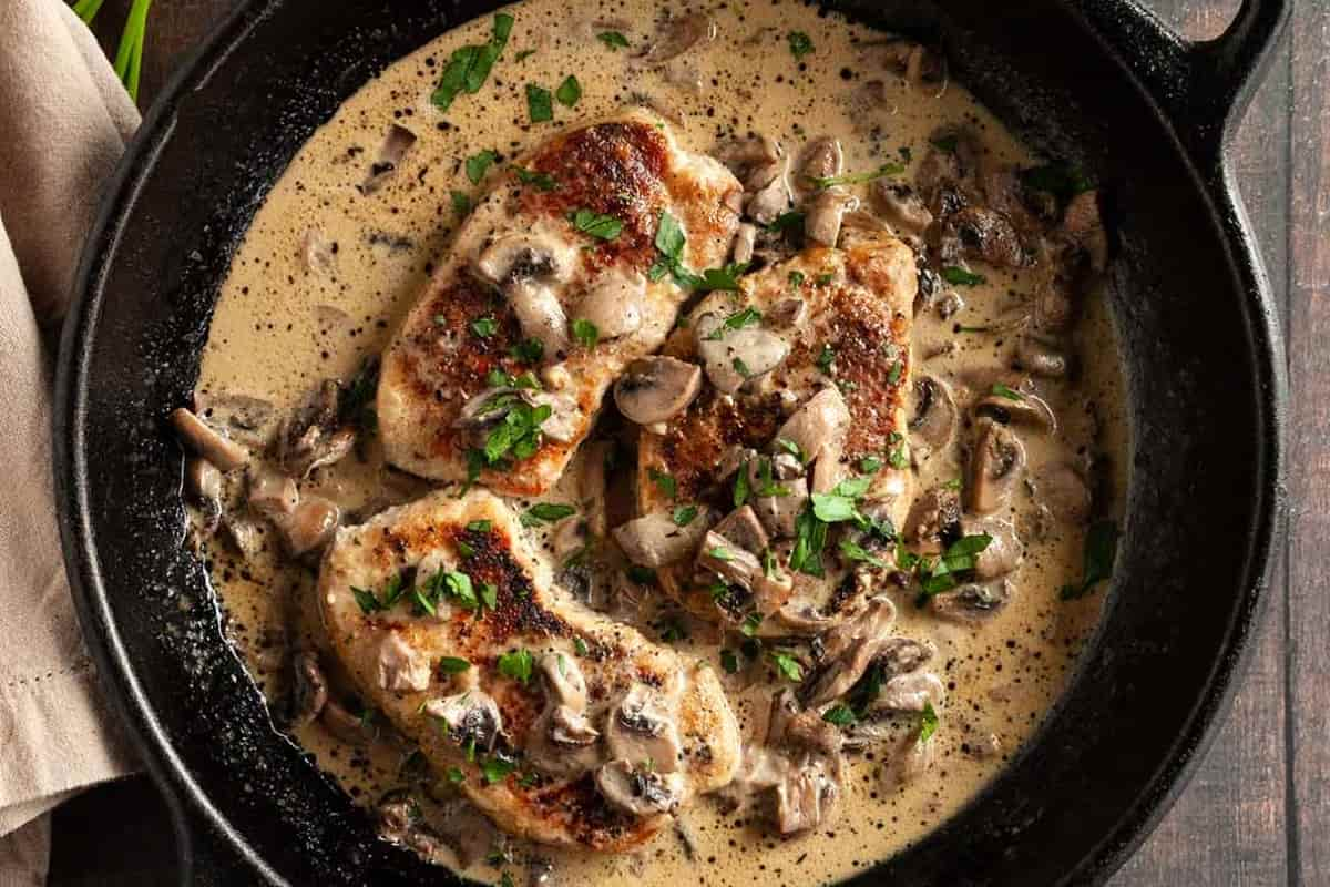 A skillet of pork chops and mushroom gravy.