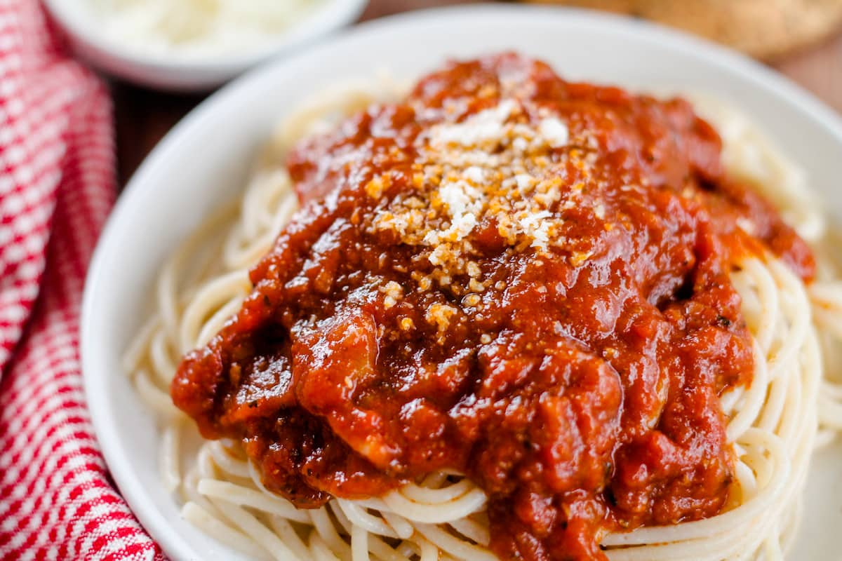 A plate of pasta with rich tomato sauce.