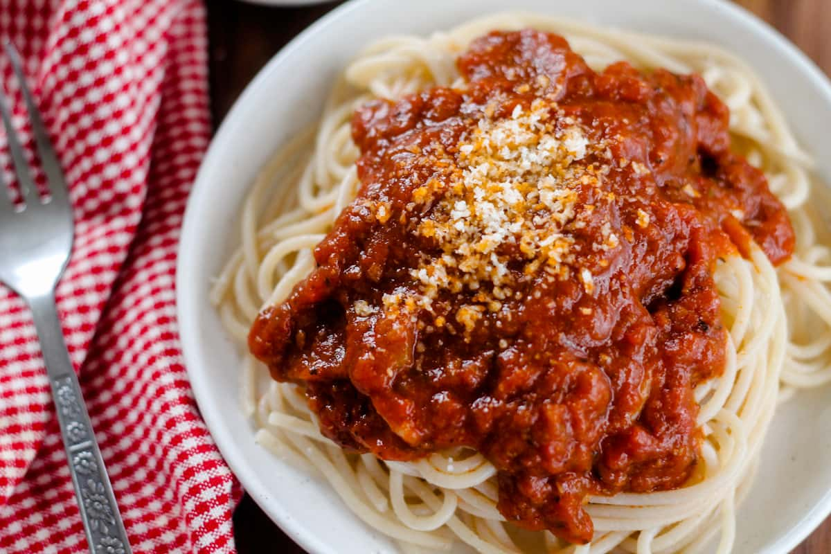 A plate of pasta with rich tomato sauce.