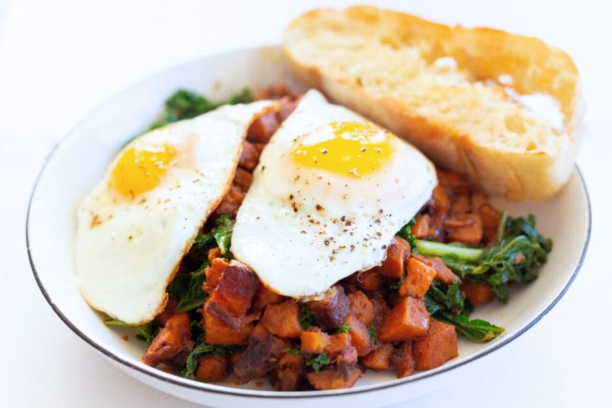 A plate of Sweet Potato Kale Hash with Sunny-Side-Up Egg.