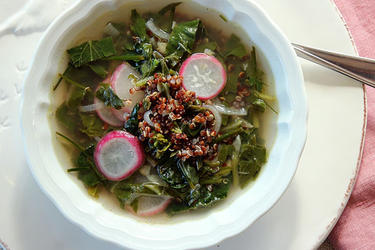 A bowl of Quinoa Soup With Spring Greens.