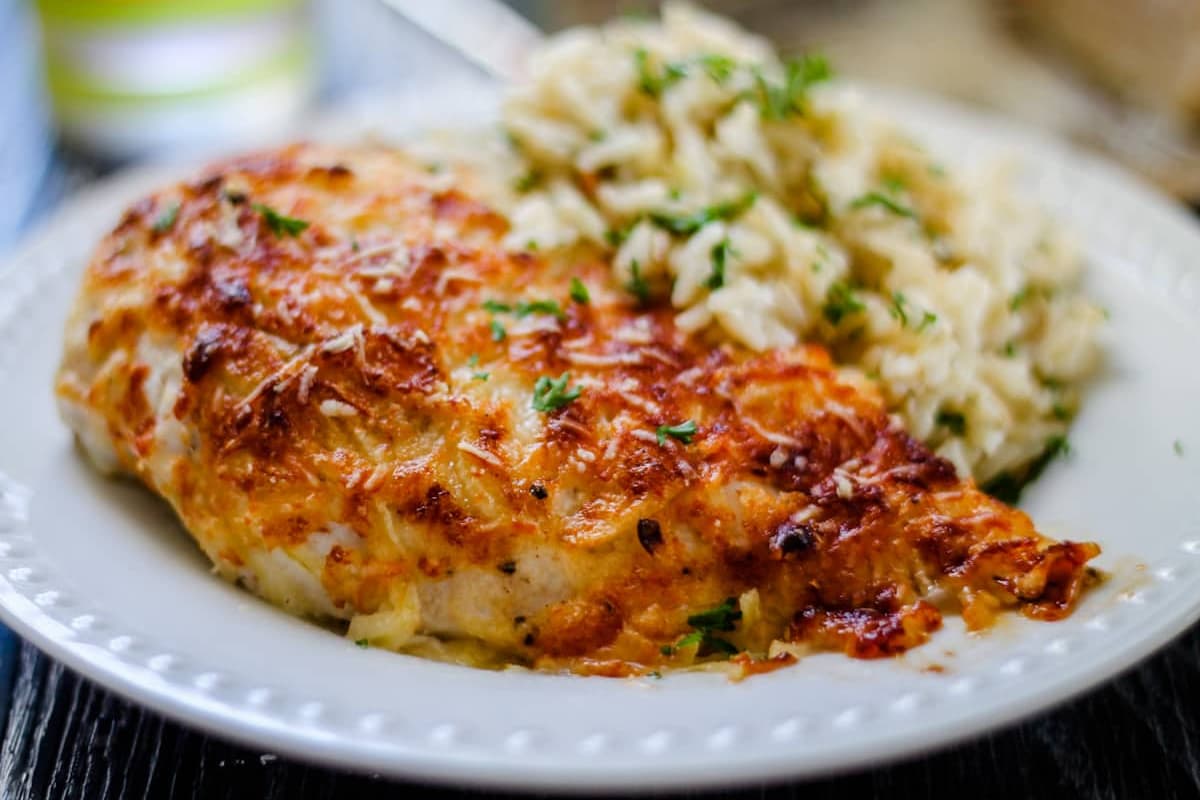 A plate of baked parmesan chicken breasts.