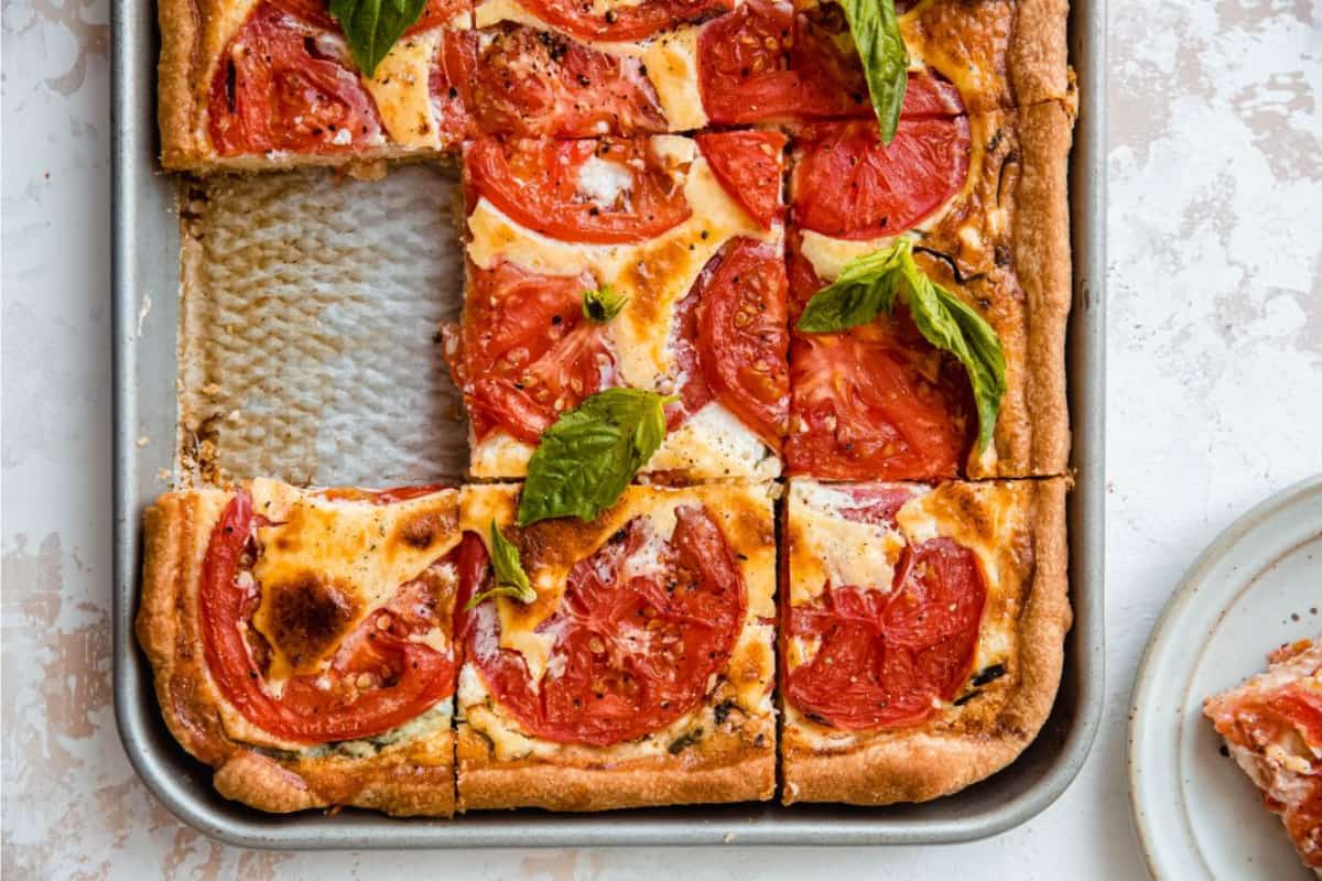 A Sheet Pan Tomato Quiche on a table.