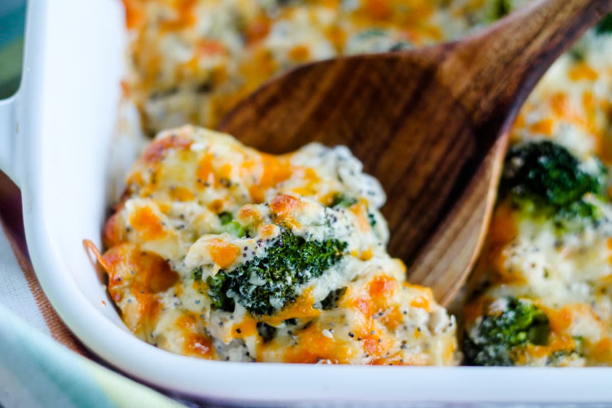 A spoon scooping everything bagel chicken casserole from a dish.